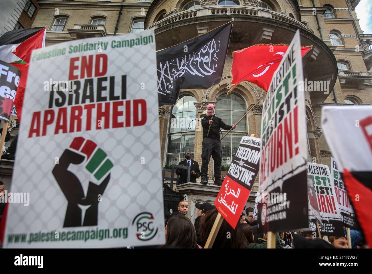 Londres, Royaume-Uni. 14 octobre 2023. Les manifestants brandissent un assortiment de pancartes en faveur de la cause palestinienne, encadrant un manifestant brandissant un drapeau en écriture arabe. Des groupes se sont réunis pour marcher jusqu'à Downing Street pour soutenir le peuple palestinien avant les représailles israéliennes après la récente attaque du Hamas contre des civils israéliens. Pour tenter de dissiper les tensions, le Ministre de l ' intérieur a rappelé aux policiers qu ' agiter des drapeaux palestiniens et utiliser des chants et des slogans pourrait contrevenir à la loi sur l ' ordre public. Crédit : SOPA Images Limited/Alamy Live News Banque D'Images