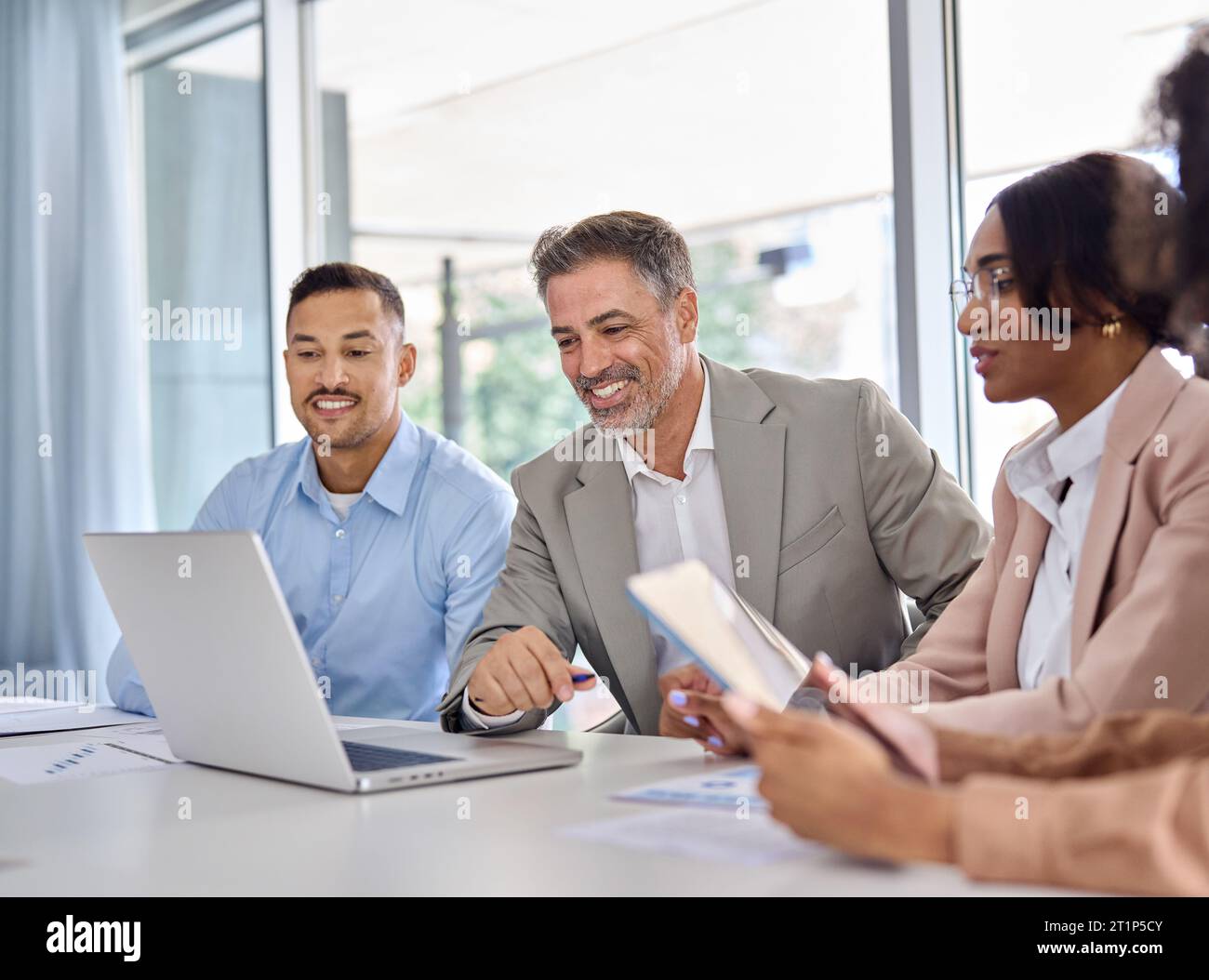 Heureux équipe diversifiée d'employés d'affaires travaillant à la réunion de groupe à l'aide d'un ordinateur portable. Banque D'Images