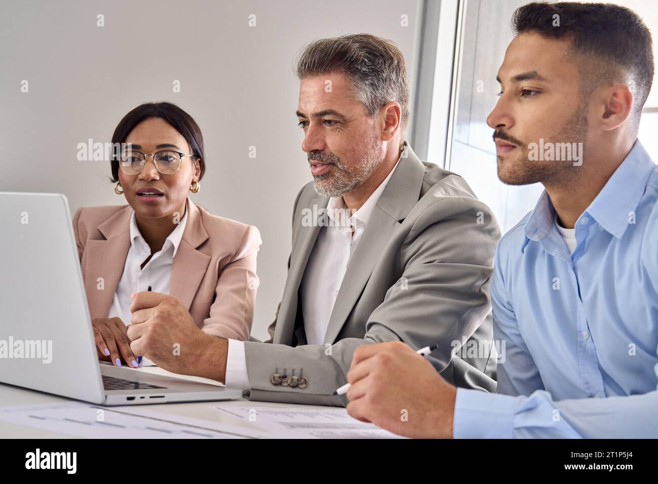 Équipe de cadres internationaux qui analyse les données bancaires numériques sur ordinateur portable. Banque D'Images