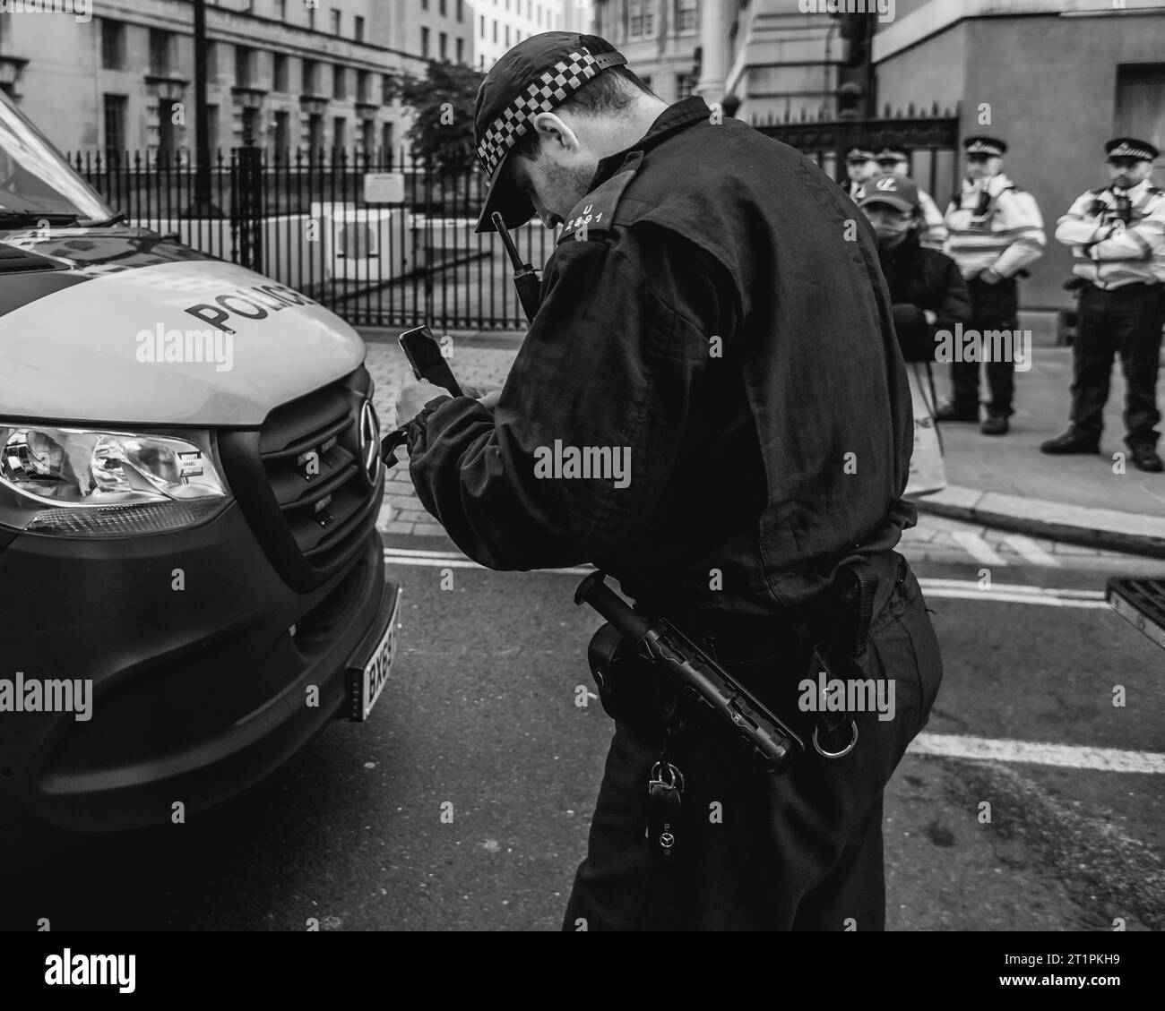 Un officier de police met prend une photo d'un autocollant Pro palestinien laissé sur le fourgon de la police lors de la marche à Londres. Banque D'Images