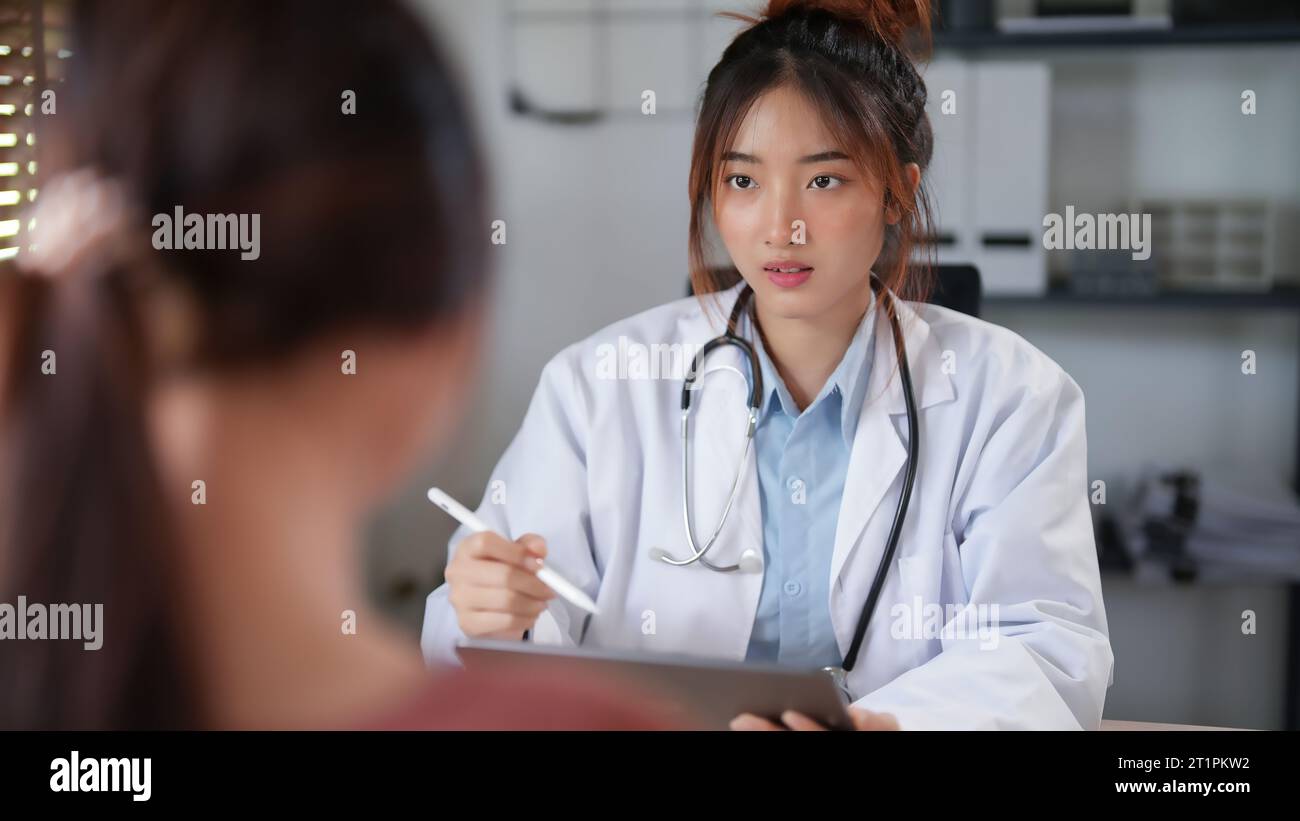 Femmes patients asiatiques avec l'anxiété expliquant au sujet du problème de santé psychologique au médecin tandis que psychologue femme écrivant des notes sur la tablette et l'avocat Banque D'Images