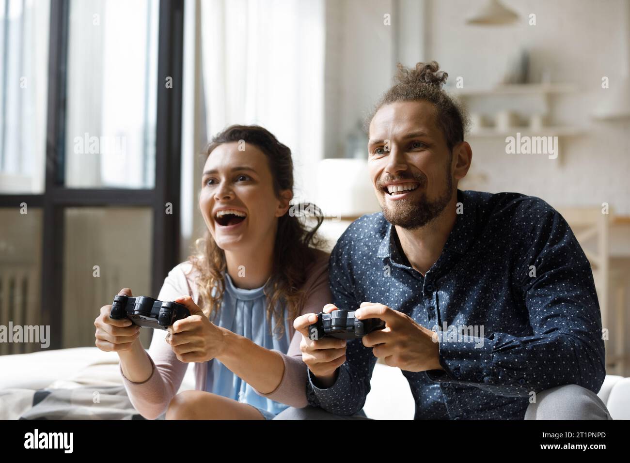 Joyeux couple excité jouant à des jeux vidéo virtuels Banque D'Images