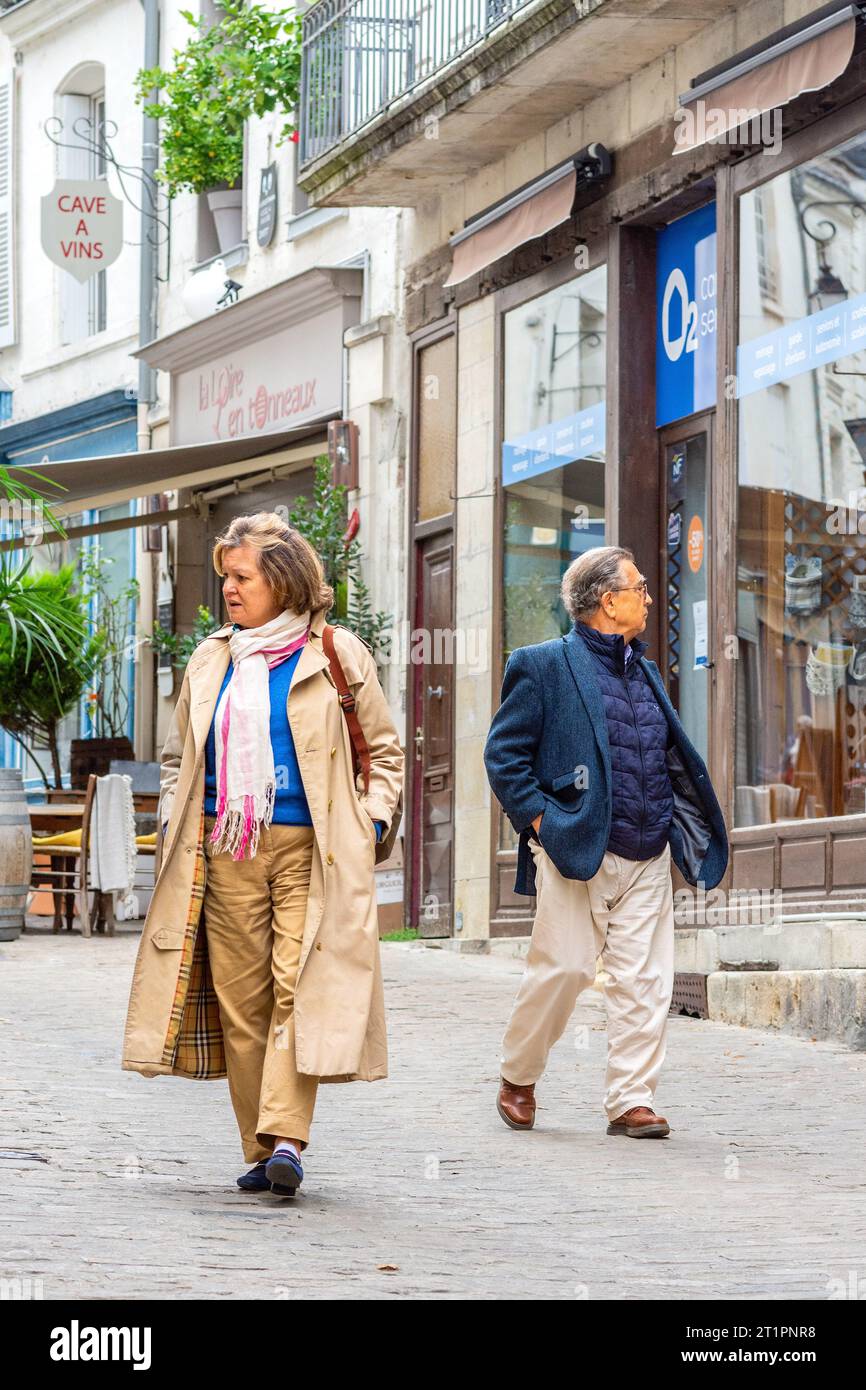 Couple mature regardant les vitrines du côté opposé de la rue étroite - Loches, Indre-et-Loire (37), France. Banque D'Images
