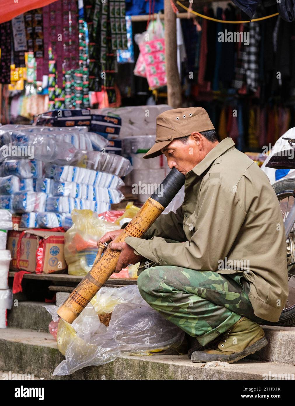 Scène du marché de CAN Cau, Vietnam. Hmong Homme fumant une pipe en bambou. Province de Lao Cai. Banque D'Images
