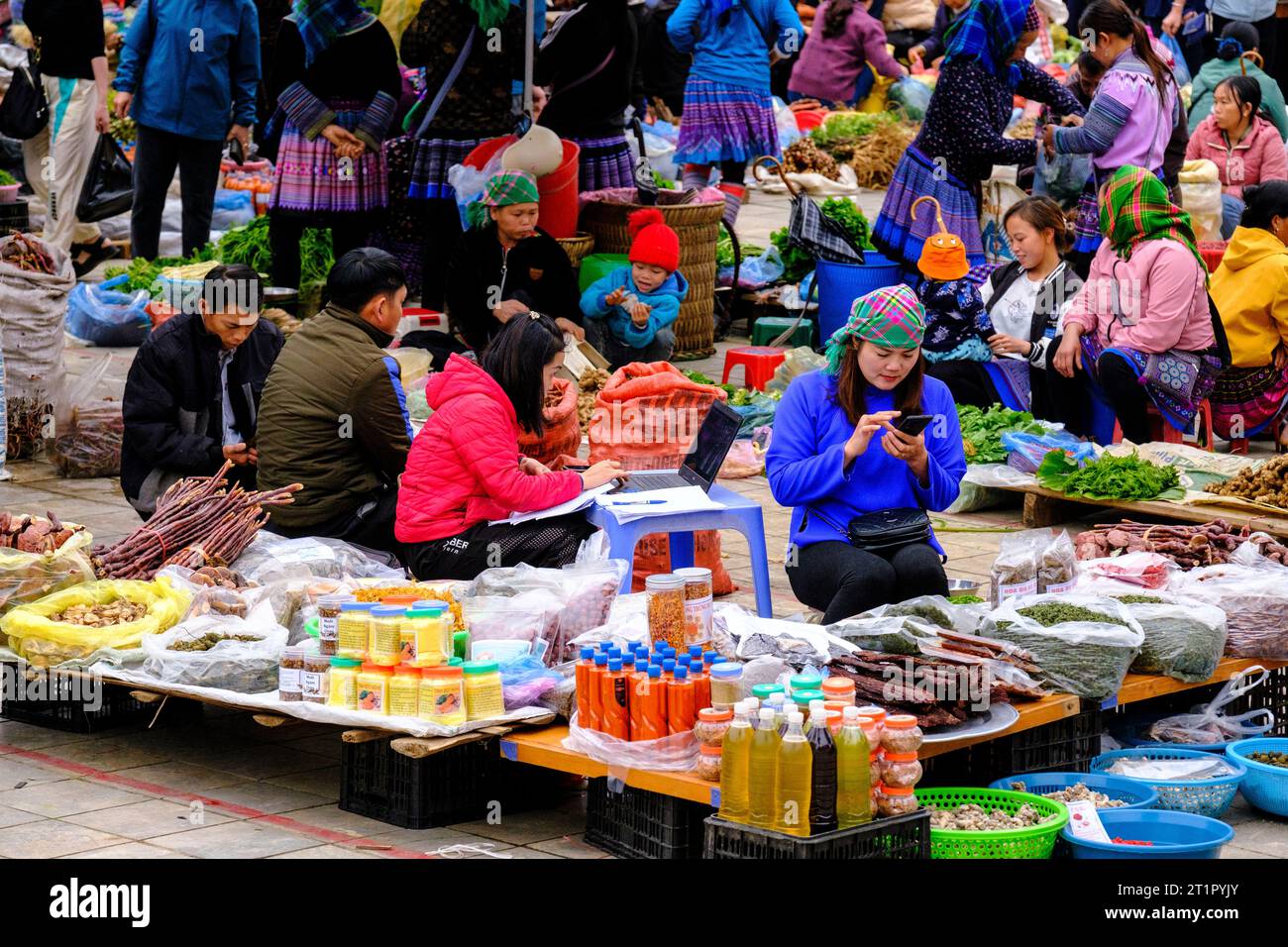 Bac Ha, Vietnam. Scène du marché du dimanche. Femmes travaillant sur ordinateur portable et téléphone portable. Province de Lao Cai. Banque D'Images