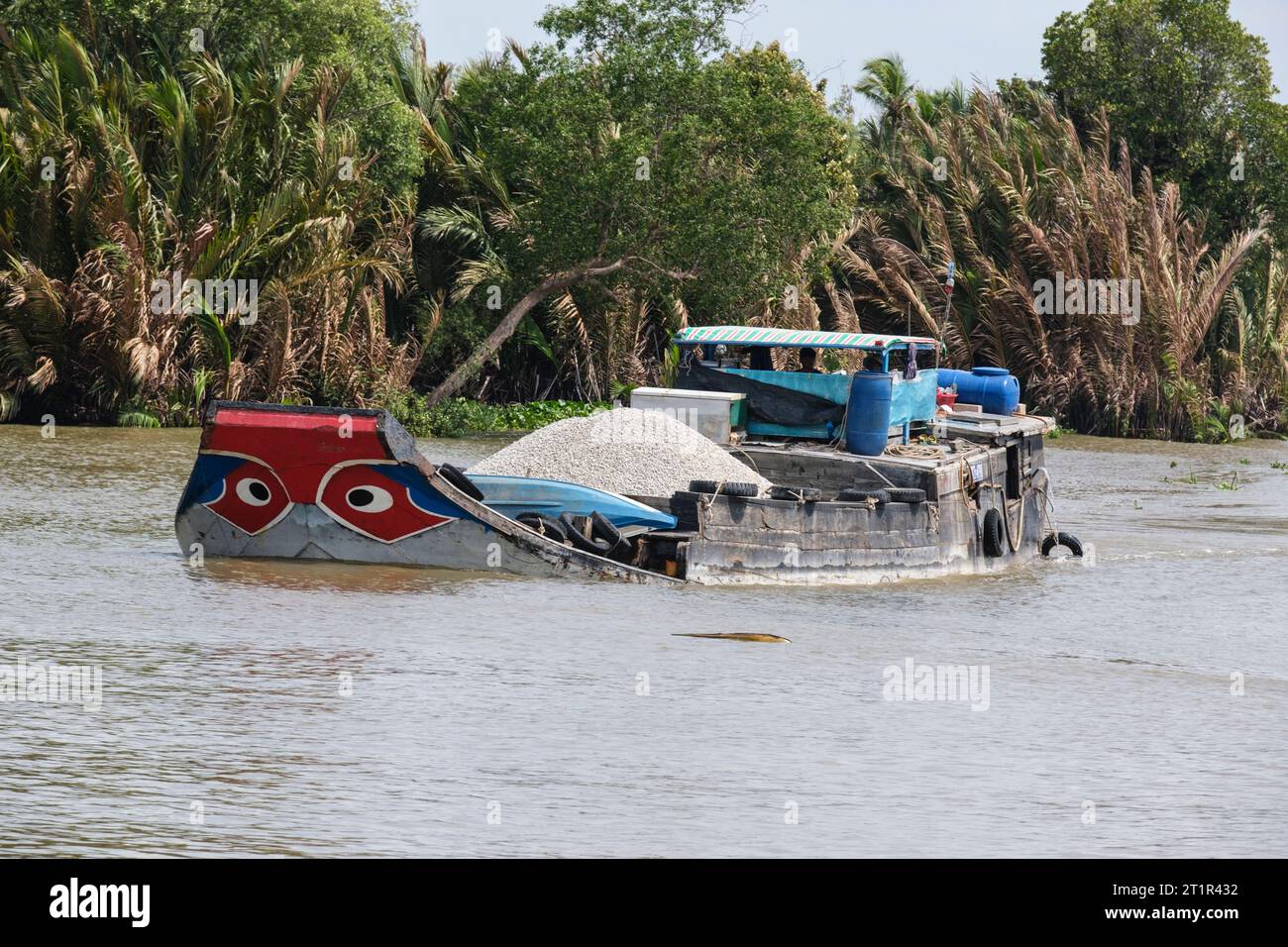 Trafic fluvial sur la rivière Saigon, Vietnam. Les yeux noirs dans le cercle blanc sur la proue de bateau sont la protection traditionnelle contre Evil River Spirits. Banque D'Images