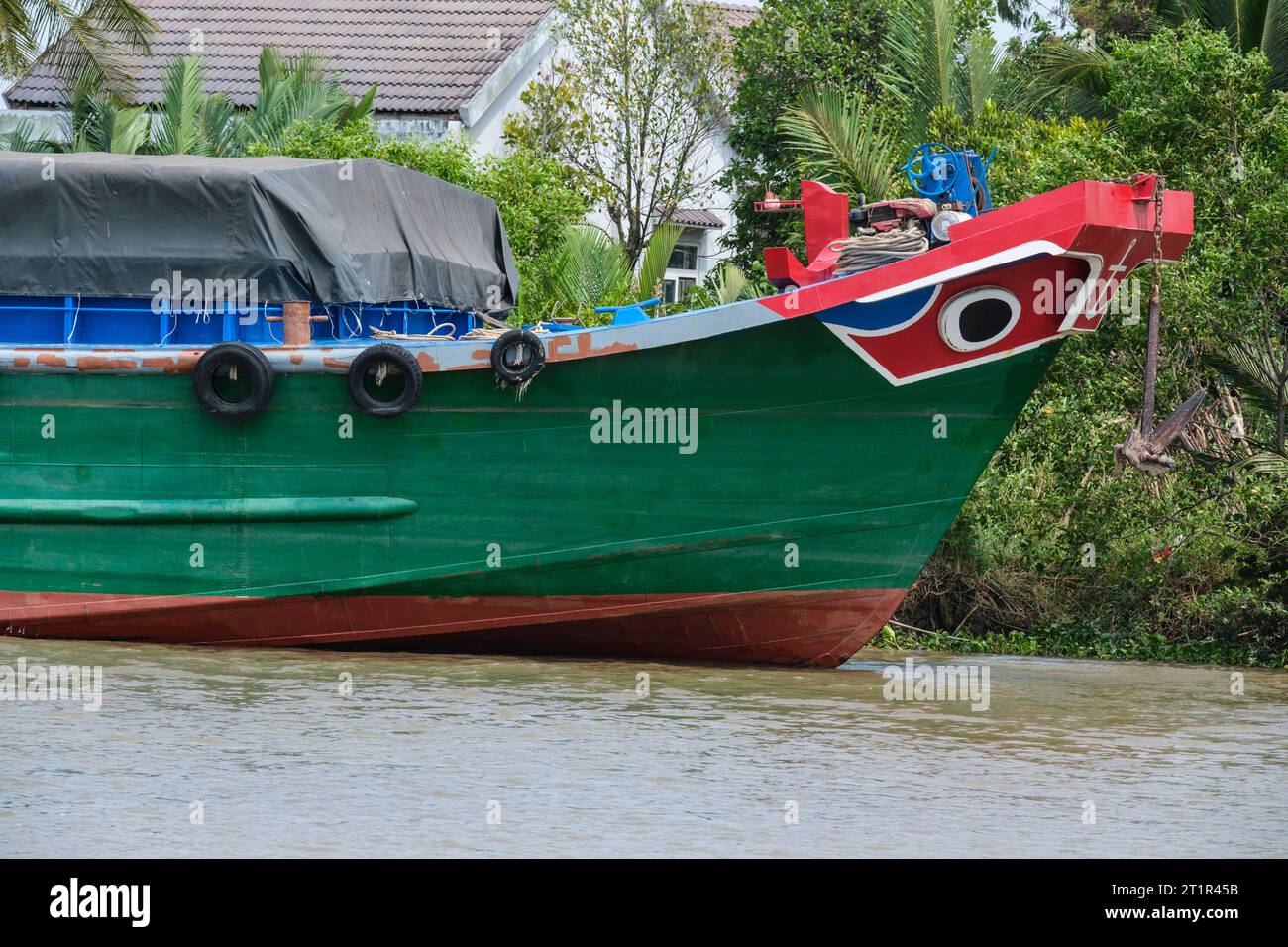 Trafic fluvial sur la rivière Saigon, près de Ho Chi Minh, Vietnam. Les yeux noirs dans le cercle blanc sur la proue du bateau sont la protection traditionnelle. Banque D'Images
