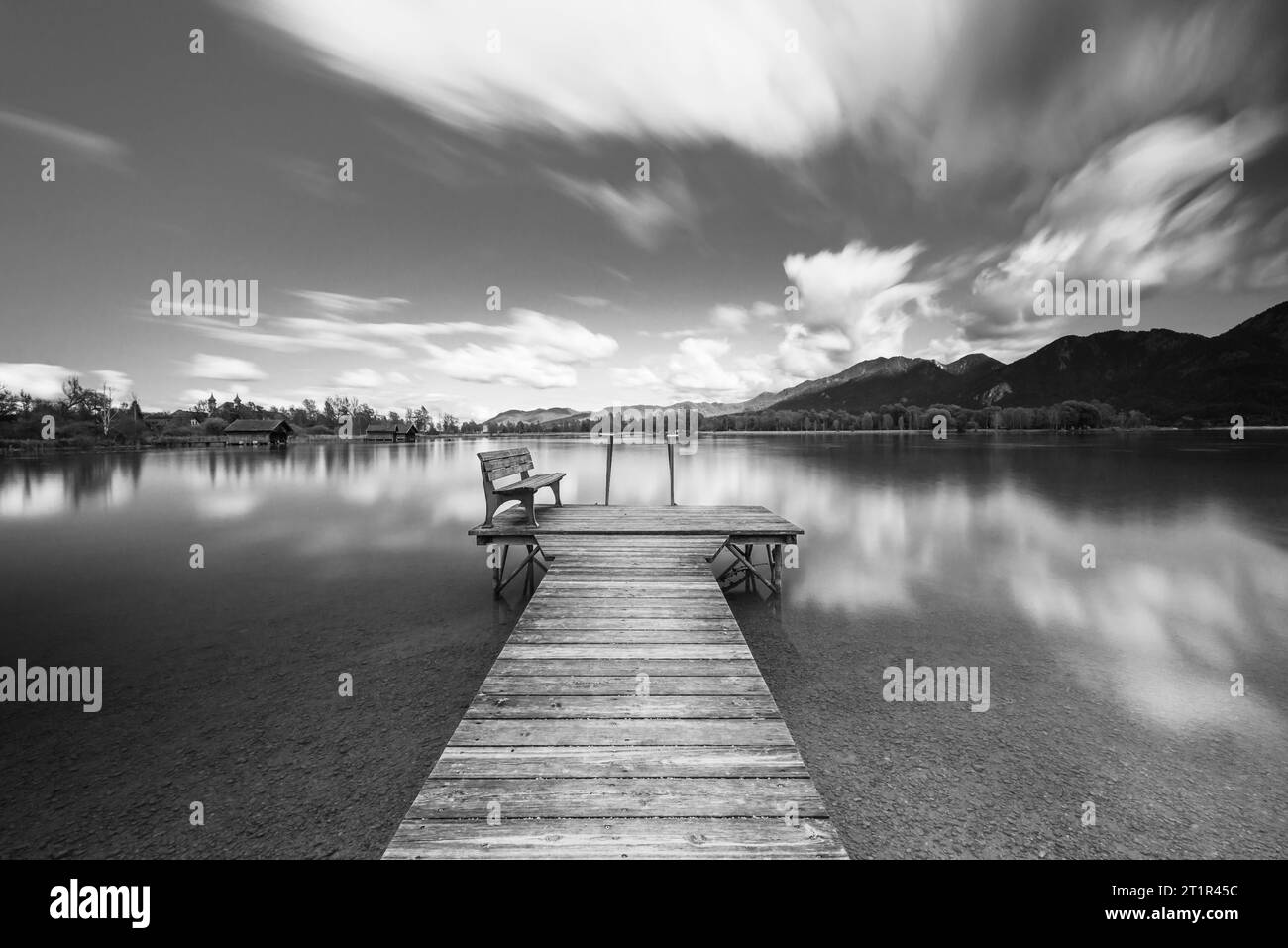 Nuages dérivant sur une passerelle en bois sur la rive du lac Kochelsee devant un paysage montagneux automnal et nuages dans le ciel, Bavière Banque D'Images