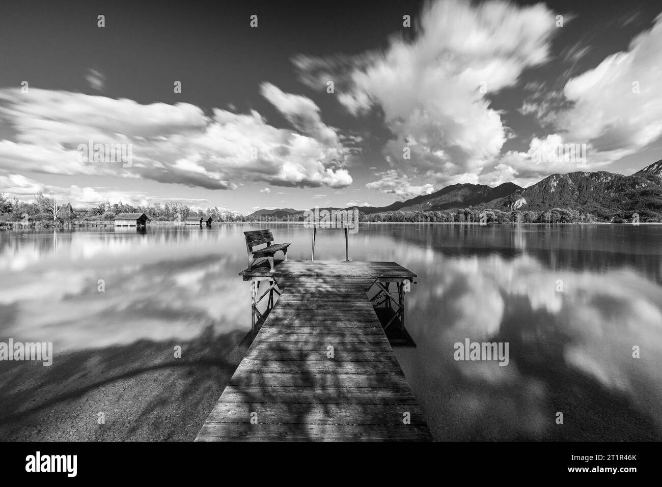Nuages dérivant sur une passerelle en bois sur la rive du lac Kochelsee devant un paysage montagneux automnal et nuages dans le ciel, Bavière Banque D'Images