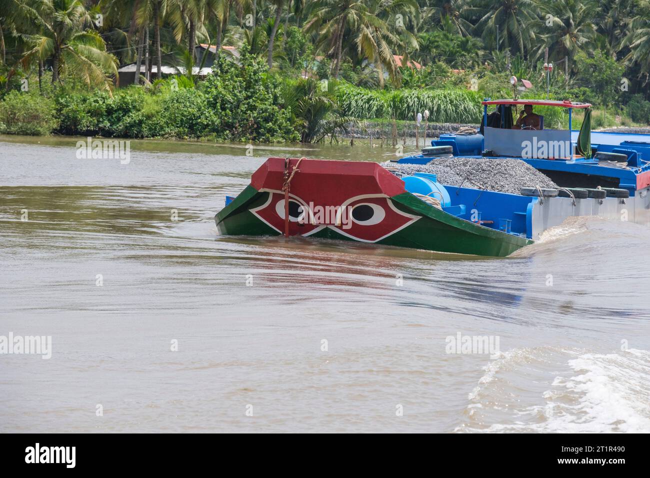 Trafic fluvial sur la rivière Saigon, Vietnam. Les yeux noirs dans le cercle blanc sur la proue de bateau sont la protection traditionnelle contre Evil River Spirits. Banque D'Images