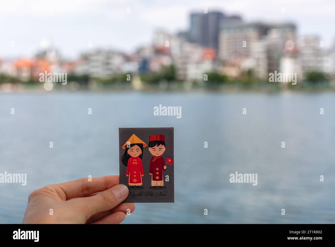 Aimant avec fille et garçon vietnamiens dans des tenues traditionnelles. Sur le fond Quan Tay Ho ou Westlake district à Hanoi, Vietnam. Banque D'Images
