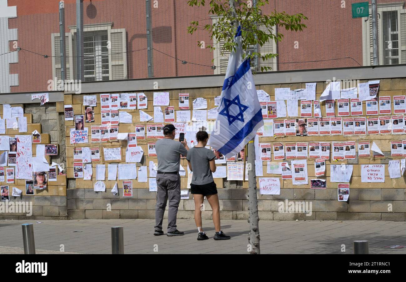 Tel Aviv, Israël. 15 octobre 2023. Les Israéliens regardent des tracts sur le mur devant le quartier général de la Défense israélienne, le HaKirya, avec des photos et des informations sur les 126 Israéliens confirmés pris en otage à Gaza par des terroristes du Hamas, le dimanche 15 octobre 2023, à tel Aviv. Israël est engagé dans une guerre avec le Hamas à la suite d'attaques à la roquette et d'un massacre de civils et de soldats à la frontière de Gaza. Photo de Debbie Hill/ crédit : UPI/Alamy Live News Banque D'Images