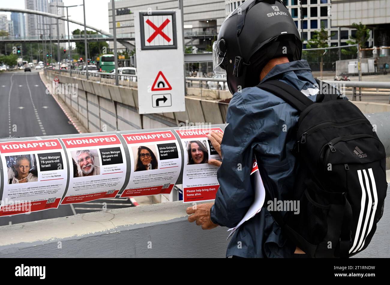 Tel Aviv, Israël. 15 octobre 2023. Un homme accroche des dépliants sur un pont près du quartier général de la Défense israélienne, le HaKirya, avec des photos et des informations des 126 Israéliens confirmés pris en otage à Gaza par des terroristes du Hamas, le dimanche 15 octobre 2023, à tel Aviv. Israël est engagé dans une guerre avec le Hamas à la suite d'attaques à la roquette et d'un massacre de civils et de soldats à la frontière de Gaza. Photo de Debbie Hill/ crédit : UPI/Alamy Live News Banque D'Images