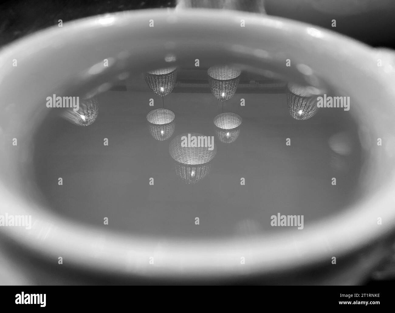 Réflexion de lumières noires et blanches dans une tasse de fond de thé, papier peint abstrait Banque D'Images