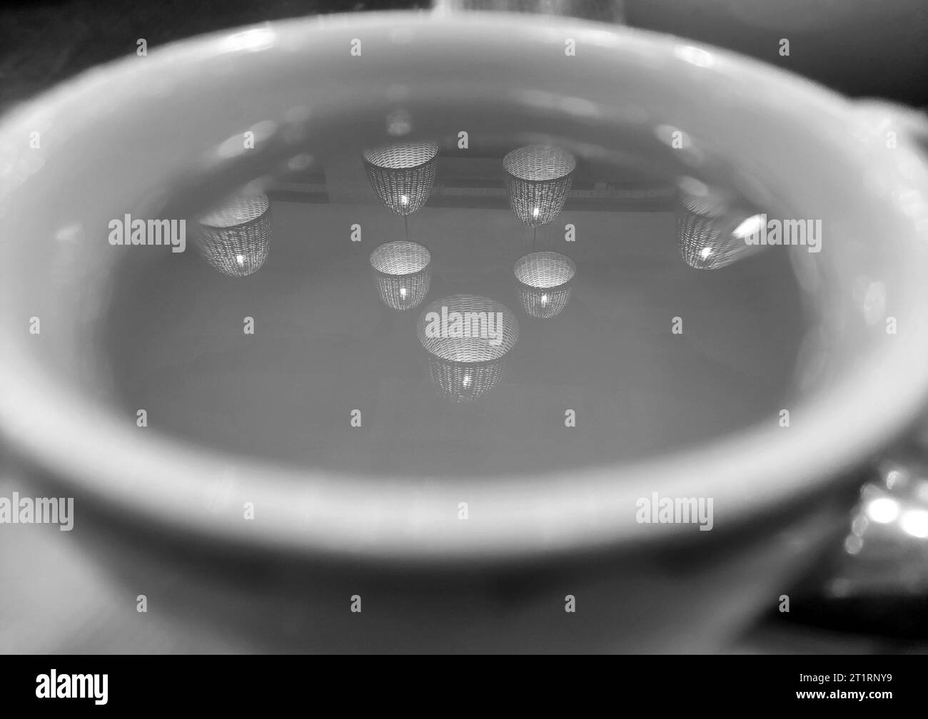 Réflexion de lumières noires et blanches dans une tasse de fond de thé, papier peint abstrait Banque D'Images