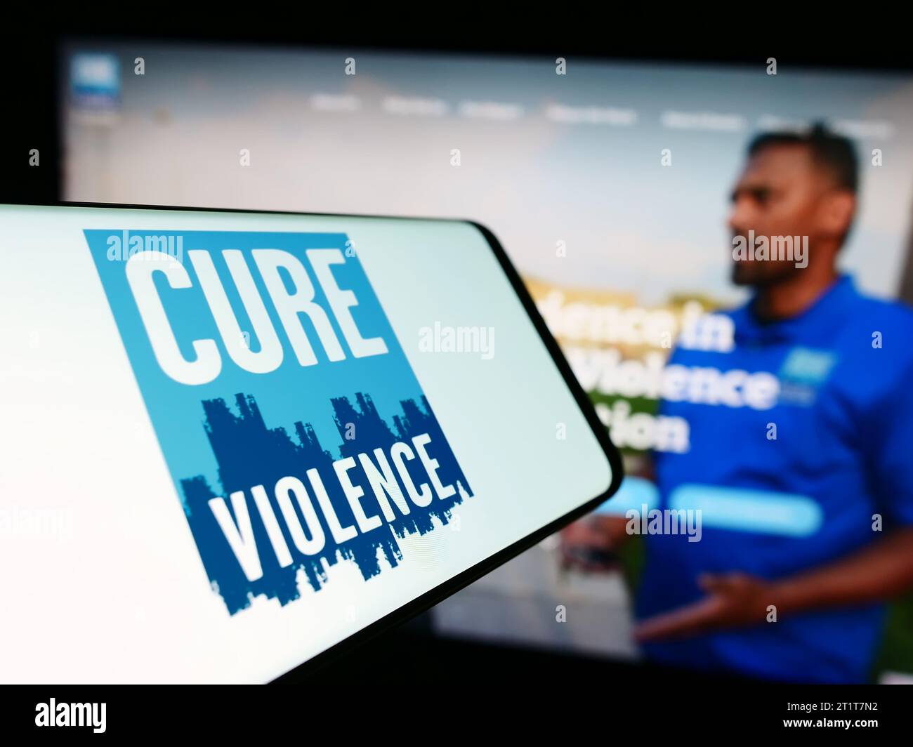 Smartphone avec le logo de l'organisation américaine Cure violence Global devant le site Web. Concentrez-vous sur le centre de l'écran du téléphone. Banque D'Images