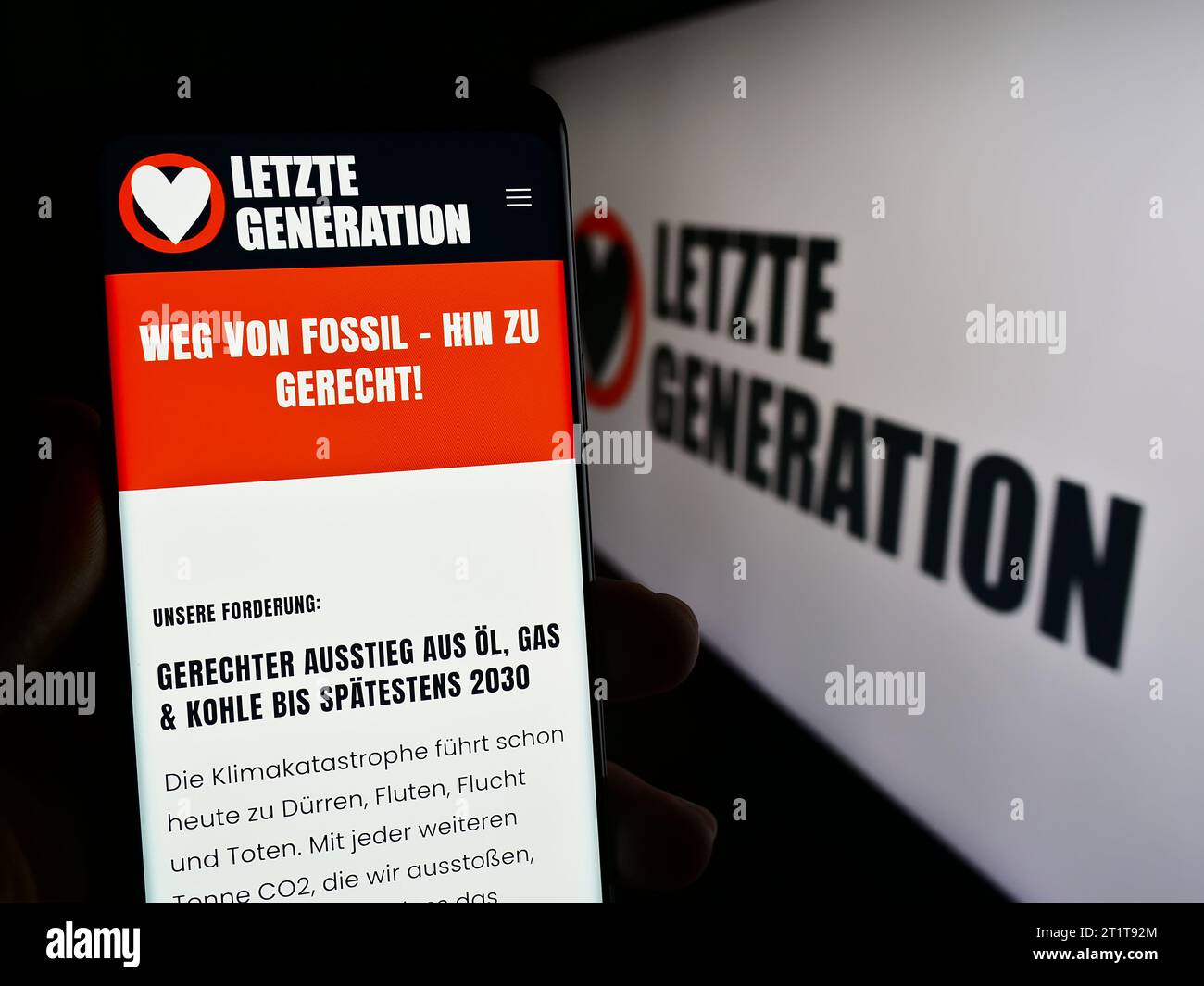 Personne tenant un téléphone portable avec une page Web du groupe militant contre le changement climatique Letzte Generation (LG) avec logo. Concentrez-vous sur le centre de l'écran du téléphone. Banque D'Images