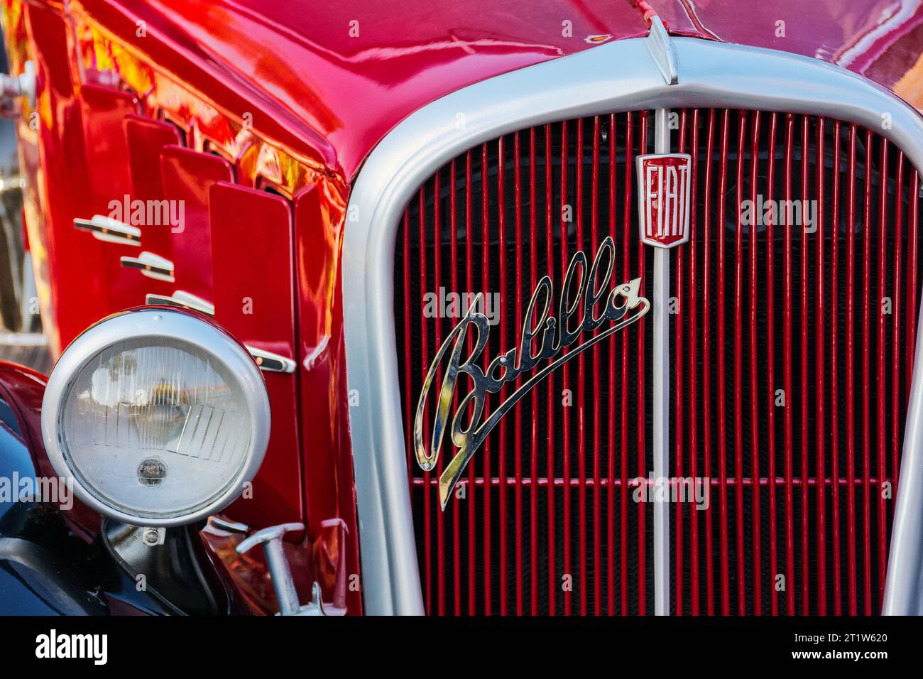 uzhgorod, ukraine - 31 octobre 2021 : gros plan avant d'un oldtimer rouge fiat 508 balilla avec logo chromé sur la calandre. ensoleillé en plein air dans le parc d'automne Banque D'Images