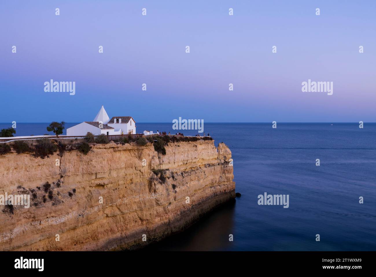 Vue sur la grande falaise et la chapelle de notre-Dame du Rocher (Igreja de Nossa Senhora da Rocha). Coucher de soleil tranquille et rêveur. Porches, Algarve, po Banque D'Images