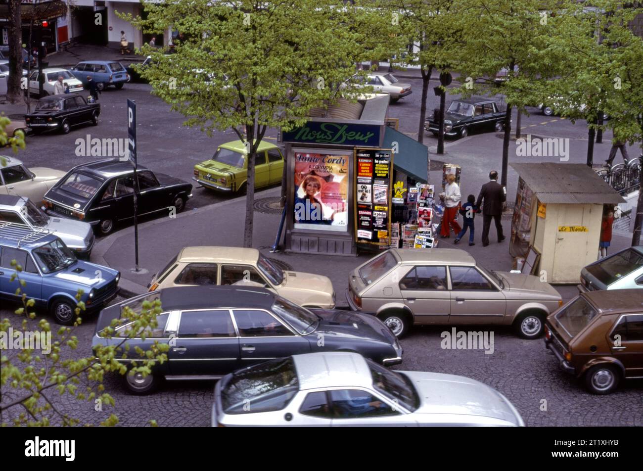 Scène de rue avec kiosque de nouvelles et trafic à Paris, France circa 1979. Banque D'Images