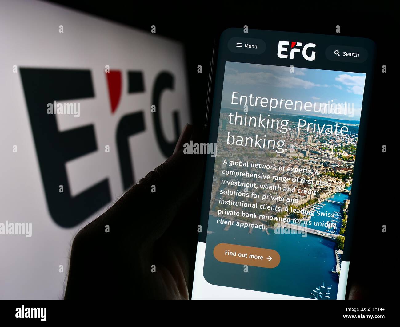 Personne détenant un téléphone portable avec la page web de la banque privée suisse EFG International AG devant le logo. Concentrez-vous sur le centre de l'écran du téléphone. Banque D'Images