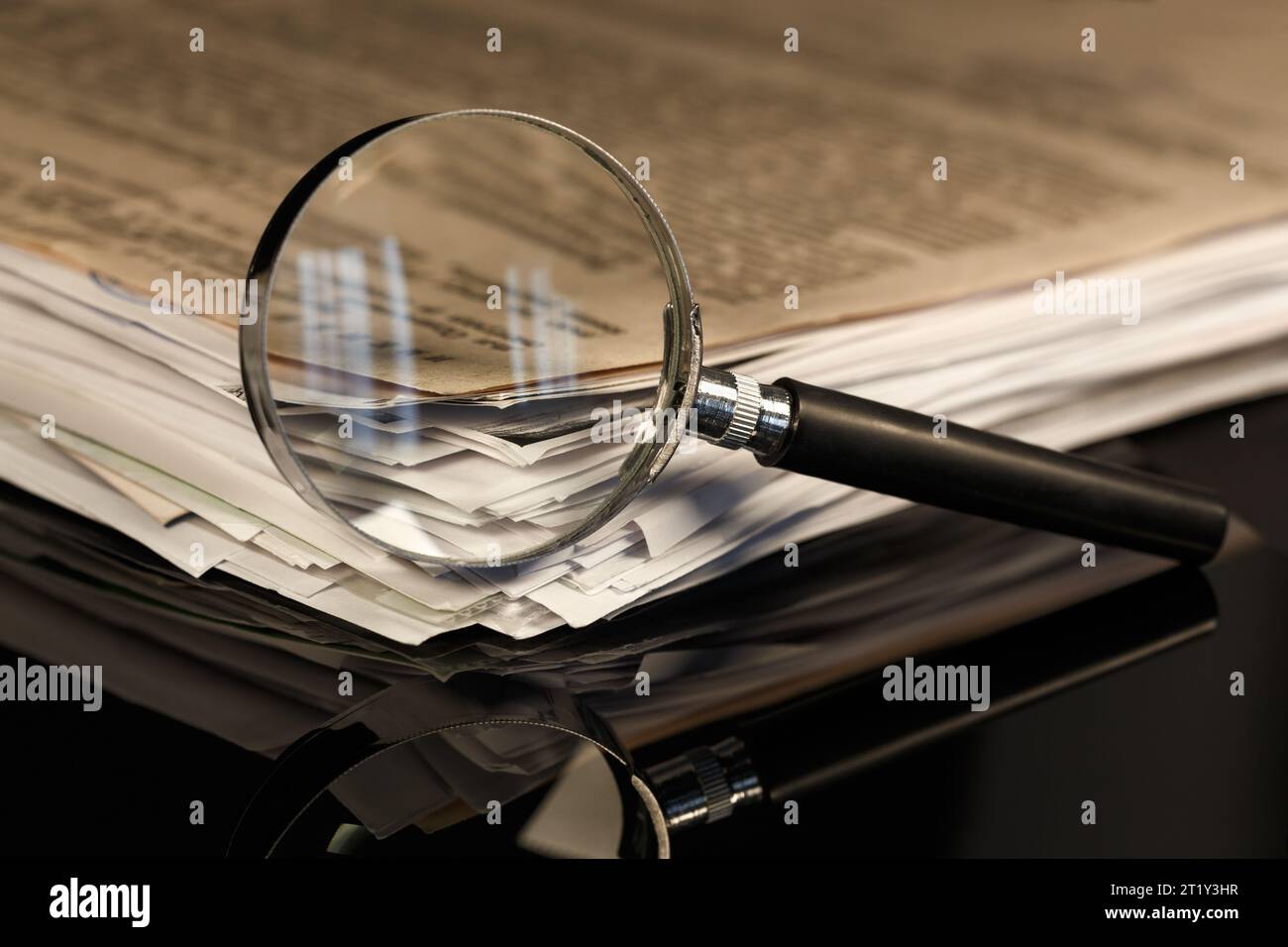 Une pile de vieux documents et une loupe. Recherche d'informations, étude. Banque D'Images