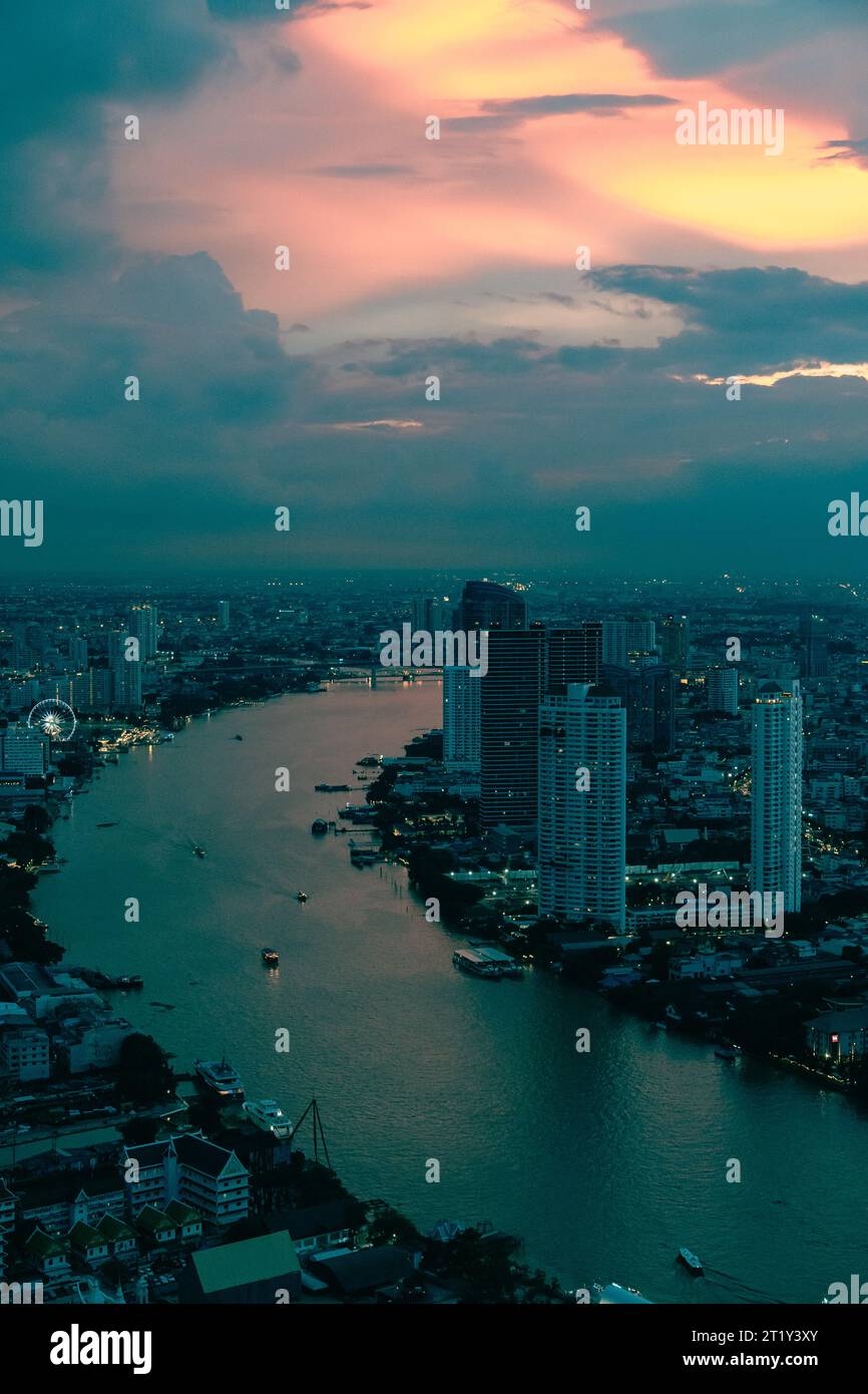 Coucher de soleil sur Bangkok. Ciel orange et nuages spectaculaires. Rivière incurvée au loin. Banque D'Images