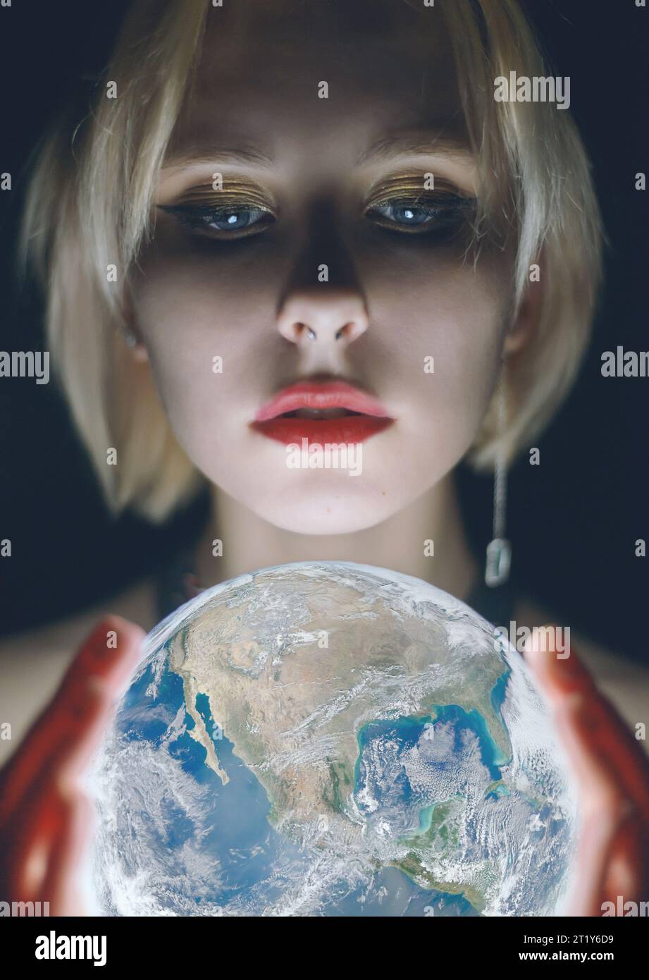 La femme tient la Terre dans sa main. Éléments de cette image fournis par la NASA Banque D'Images