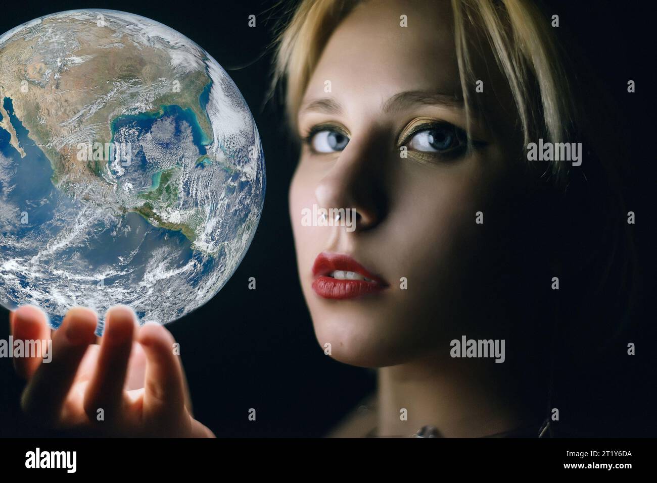 La femme tient la Terre dans sa main. Éléments de cette image fournis par la NASA Banque D'Images