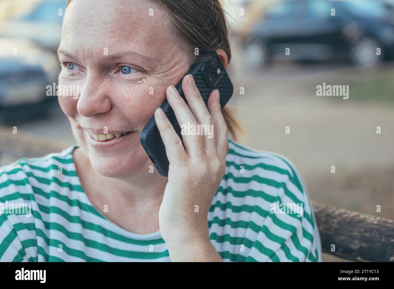 Heureuse femme joyeuse parlant sur le téléphone portable en plein air dans la rue, focalisation sélective Banque D'Images