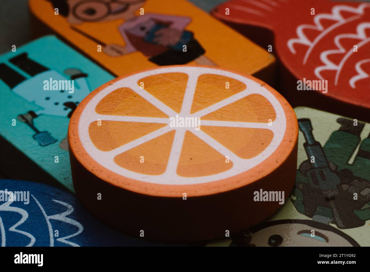 Jouets pour enfants orange tranchés en bois en couleur jaune vif et blanc Banque D'Images