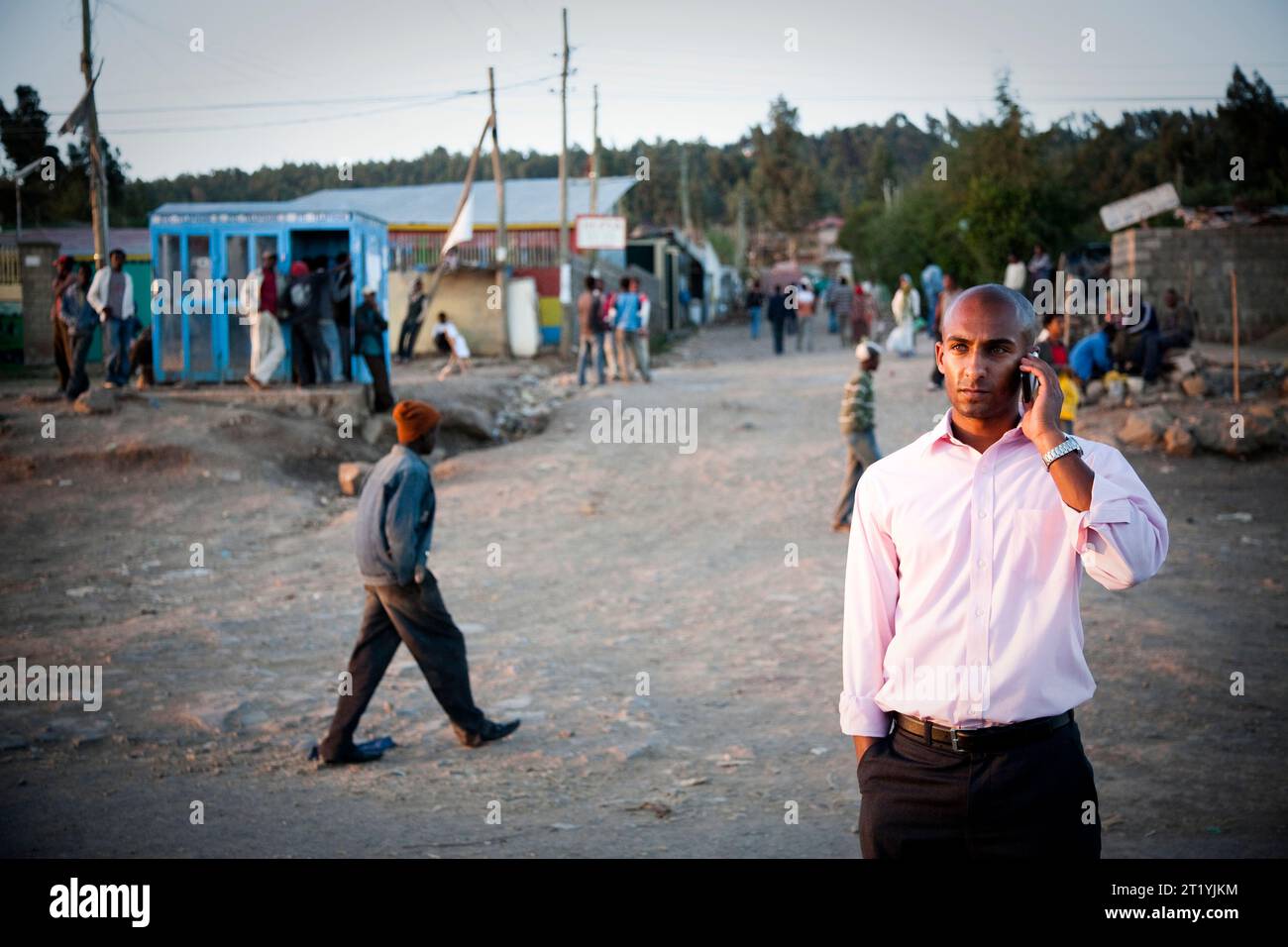 Un jeune éthiopien parle sur son téléphone portable dans une rue poussiéreuse en Éthiopie. Banque D'Images