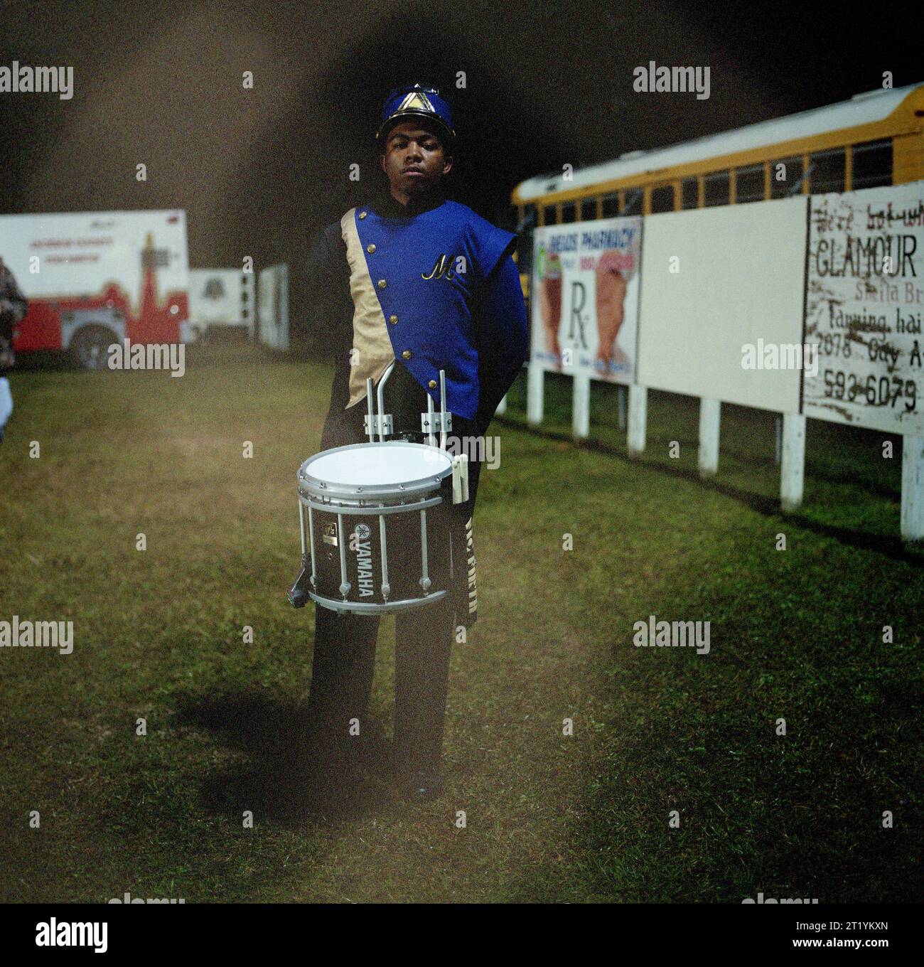 Portrait d'un jeune homme dans une fanfare de lycée avec un tambour autour de la taille. Banque D'Images