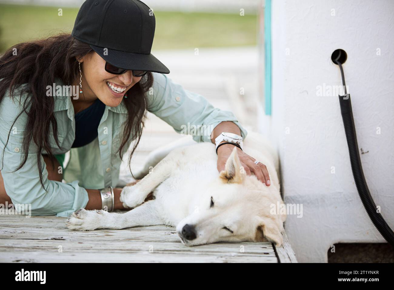 Femme jouant avec le chien sur la jetée Banque D'Images