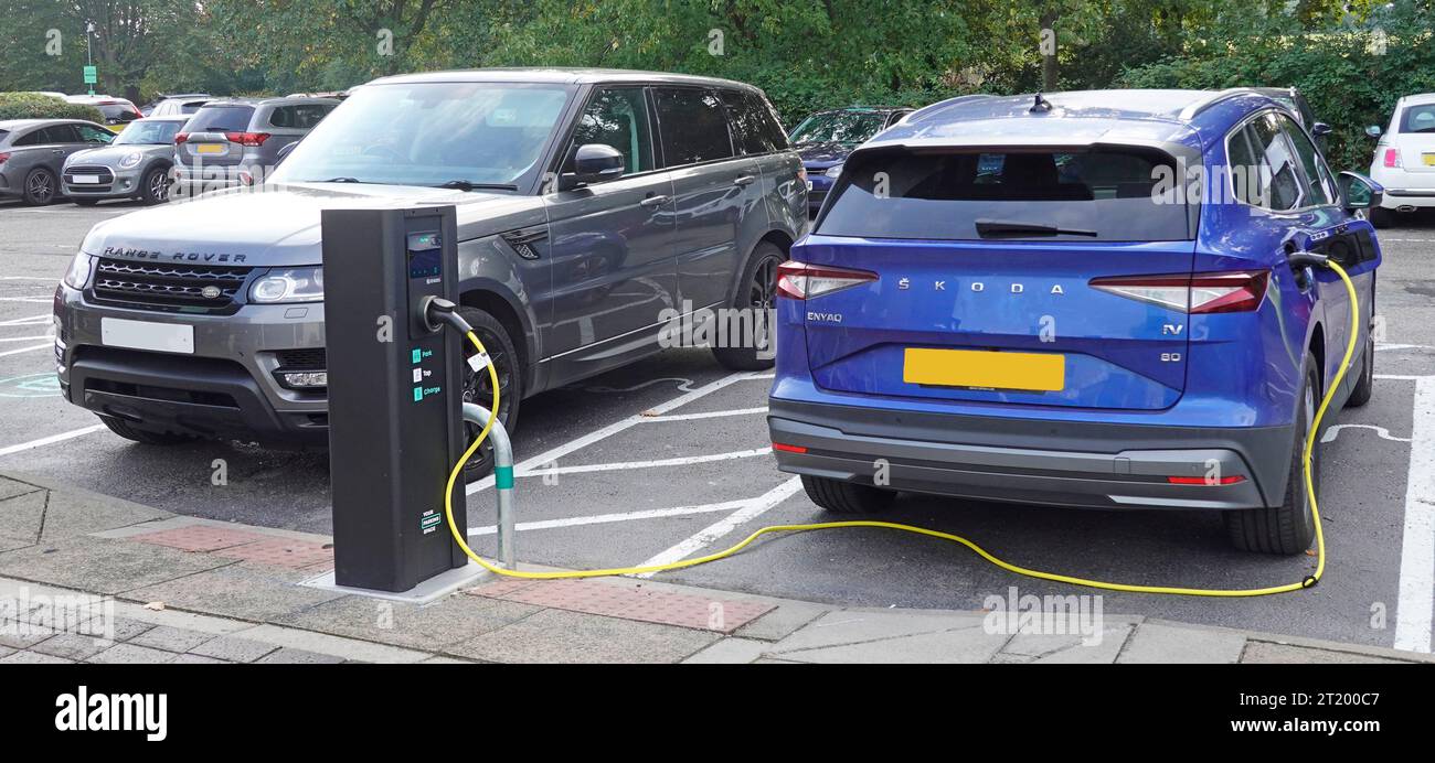 Gros plan voiture Honda électrique bleue et câble électrique branché à la borne de recharge pour les automobilistes visitant le parking Holiday Inn Essex England UK Banque D'Images