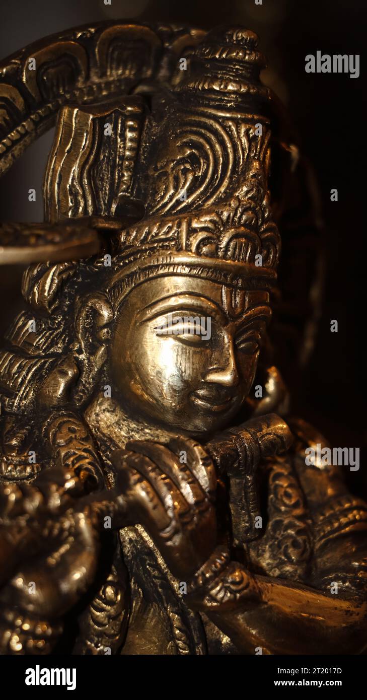 gros plan d'une sculpture en pierre brillante du dieu hindou lord krishna jouant de sa flûte à l'intérieur d'un ancien temple Banque D'Images