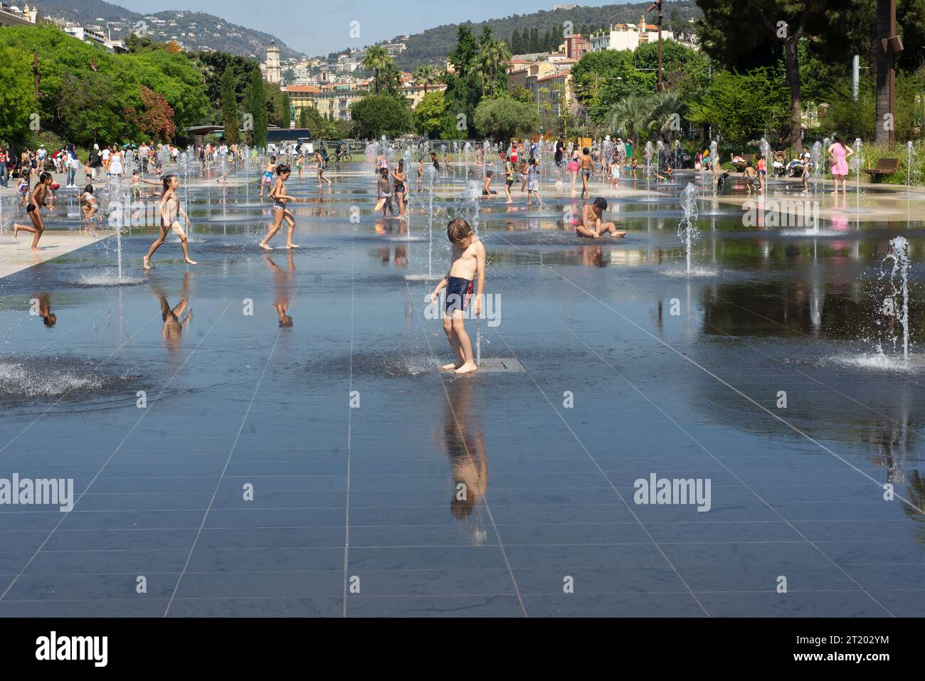 Enfants jouant sous les arroseurs d'eau Banque D'Images