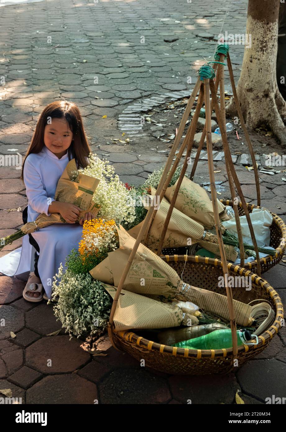 Petite fille avec des fleurs sur Phan Dinh Phung Street, Hanoi, Vietnam Banque D'Images