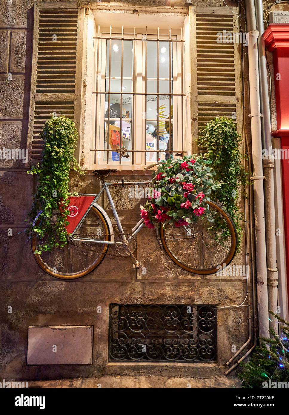 Vélo décoratif orné de fleurs et de plantes sur le mur du bâtiment historique Banque D'Images