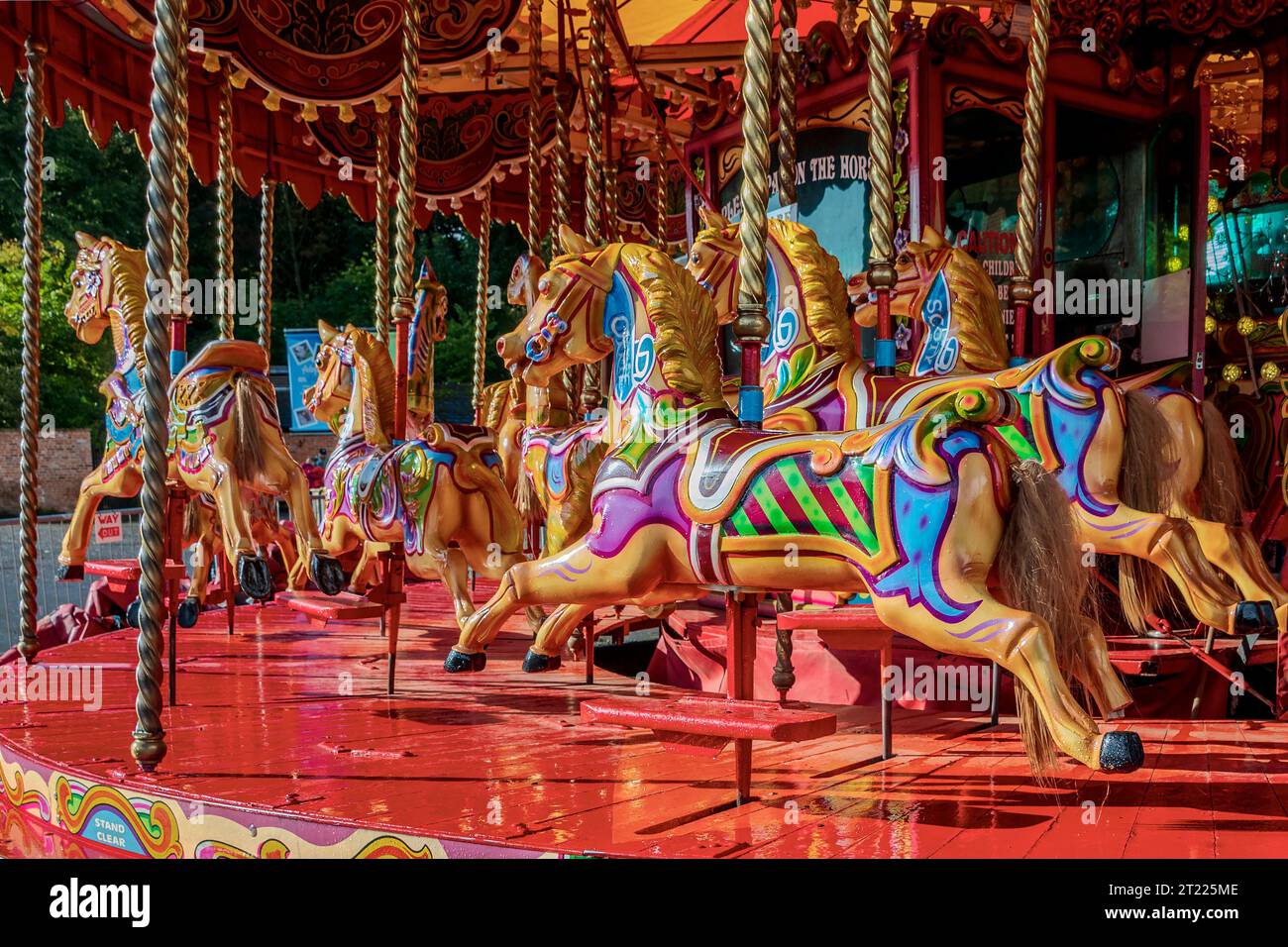 Une promenade foraine de chevaux en bois attendant les cavaliers. Banque D'Images