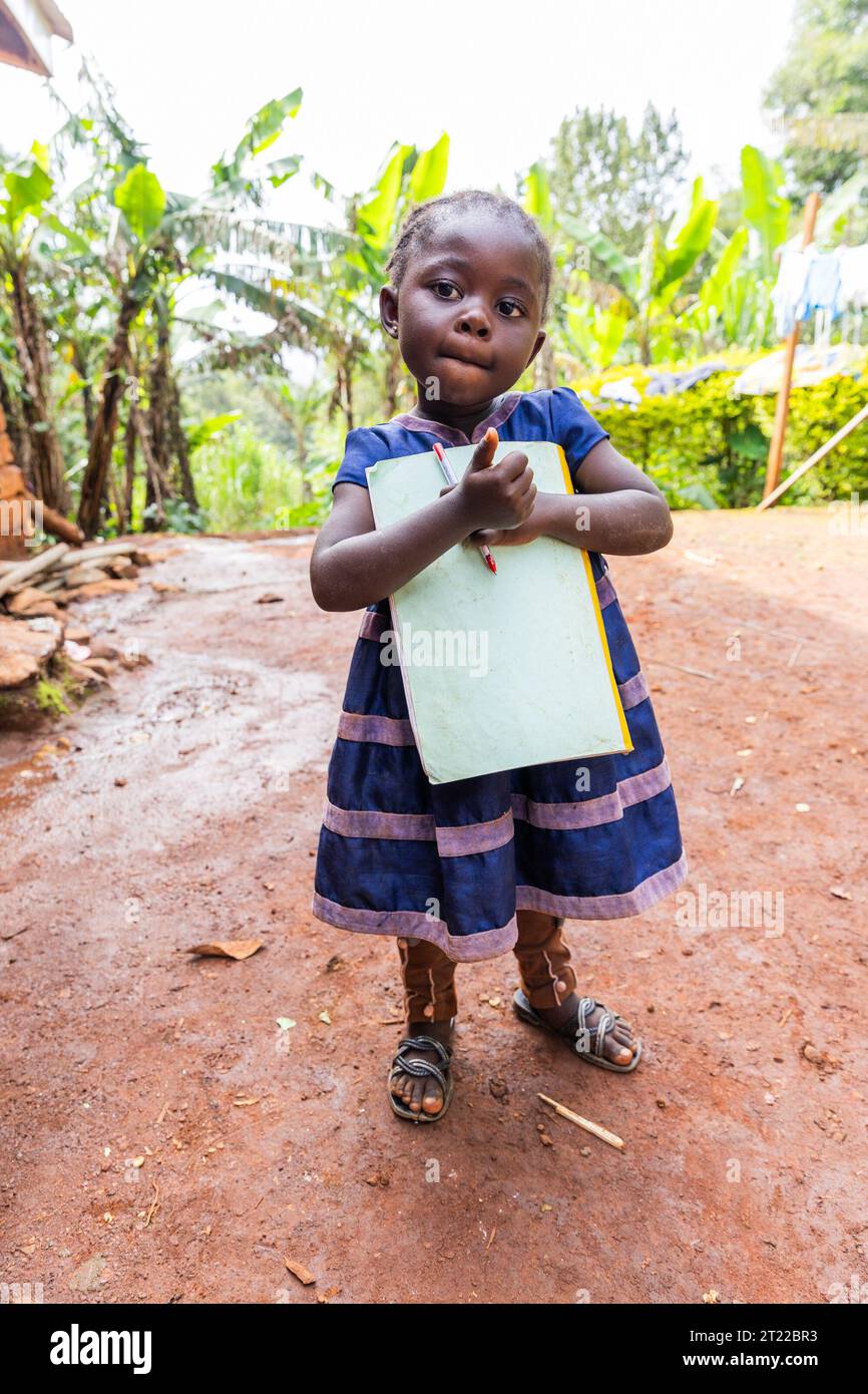 Une petite fille africaine avec son cahier et son stylo dans les mains, concept de l'éducation en Afrique Banque D'Images