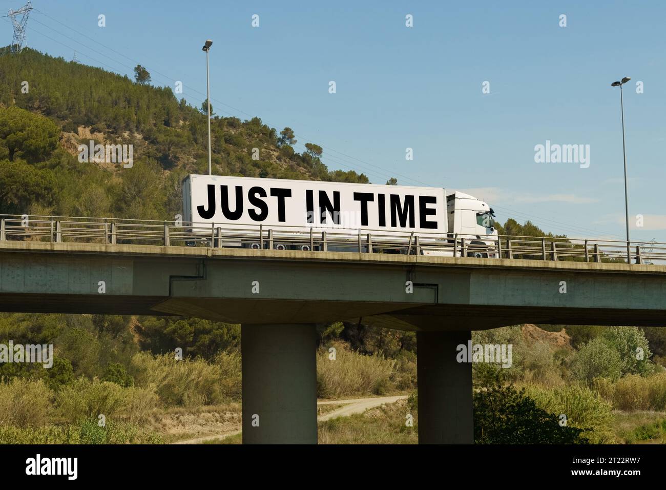 Un camion traverse le pont, avec l'inscription sur la remorque - juste à temps. Concept logistique. Banque D'Images