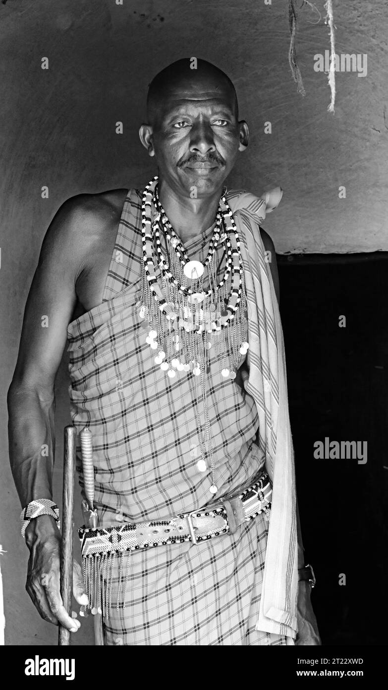 Homme tribal de Maasai Mara divertissant les visiteurs avec leur robe traditionnelle et leurs coutumes dans sa hutte dans son village Banque D'Images