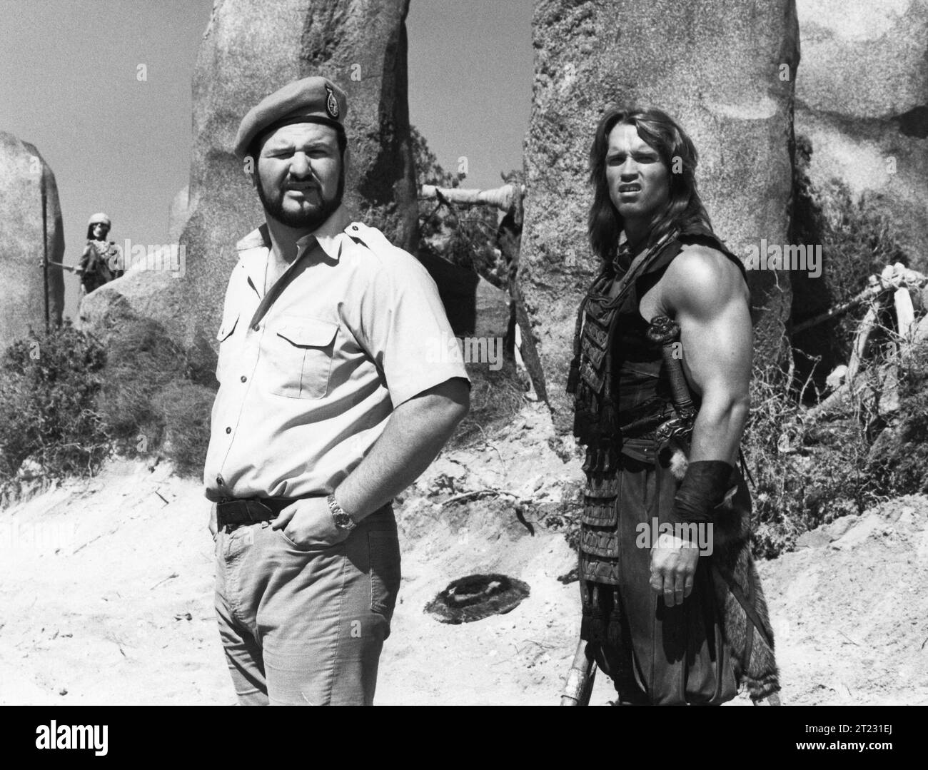 Le réalisateur JOHN MILIUS et ARNOLD SCHWARZENEGGER sur le tournage de CONAN LE personnage BARBARE 1982 créé par ROBERT E. HOWARD costume Design JOHN BLOOMFIELD musique BASIL POLEDOURIS Universal Pictures Banque D'Images