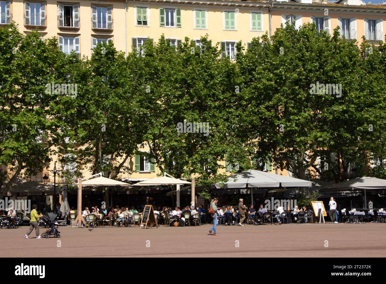 Les clients remplissent les cafés de la place Saint Nicolas bordée d’arbres à Bastia, en Corse. Banque D'Images