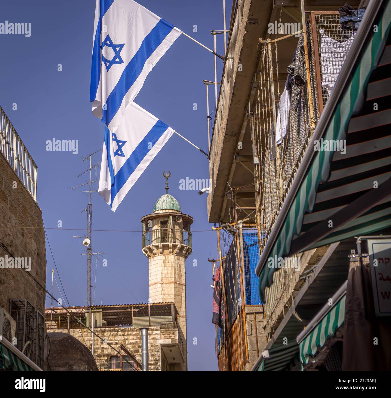 Les drapeaux israéliens sont dans les rues de la vieille ville de Jérusalem avec le minaret de la mosquée en arrière-plan, en Israël. Banque D'Images