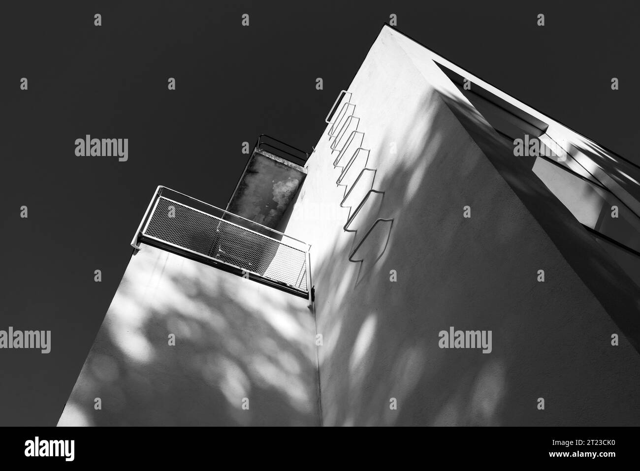 Coin de murs blancs avec escaliers métalliques sous ciel sombre, chemin d'évacuation de feu. Arrière-plan d'architecture abstraite. Photo noir et blanc Banque D'Images