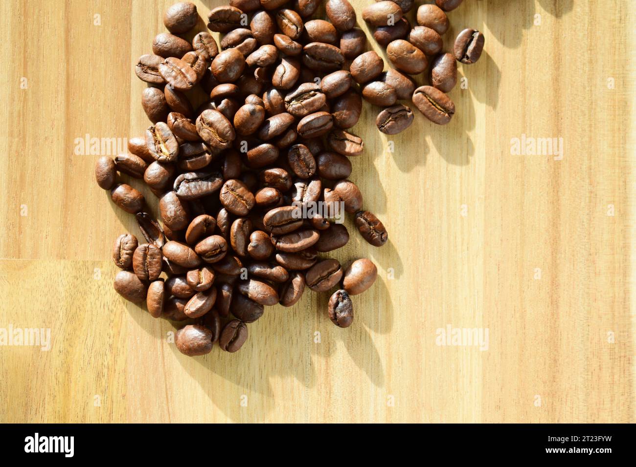 Grains de café torréfiés sur une surface en bois Banque D'Images