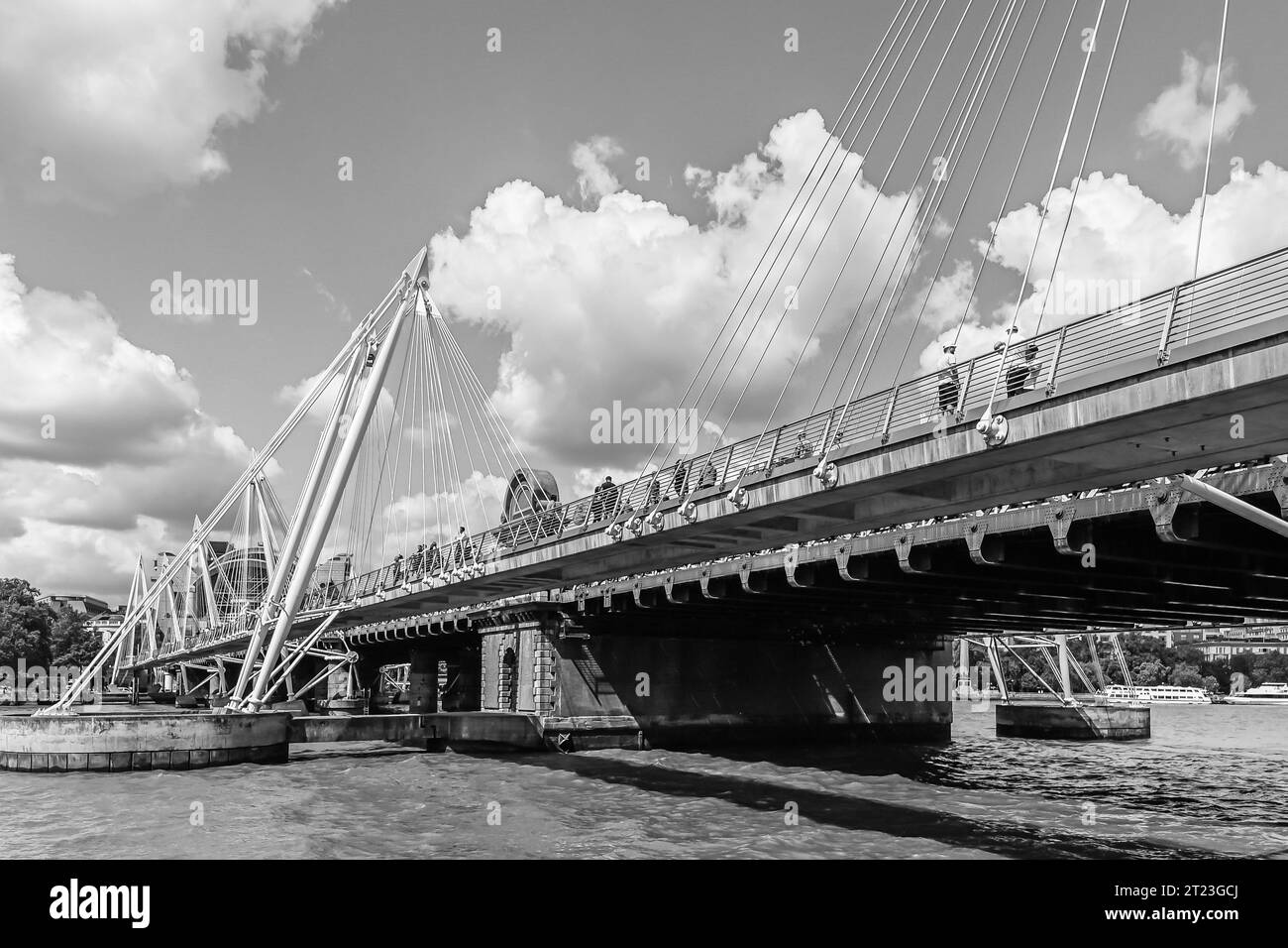 Pont ferroviaire de Hungerford et Golden Jubilee Bridges avec piétons traversant la ville de Westminster un jour d'été Banque D'Images