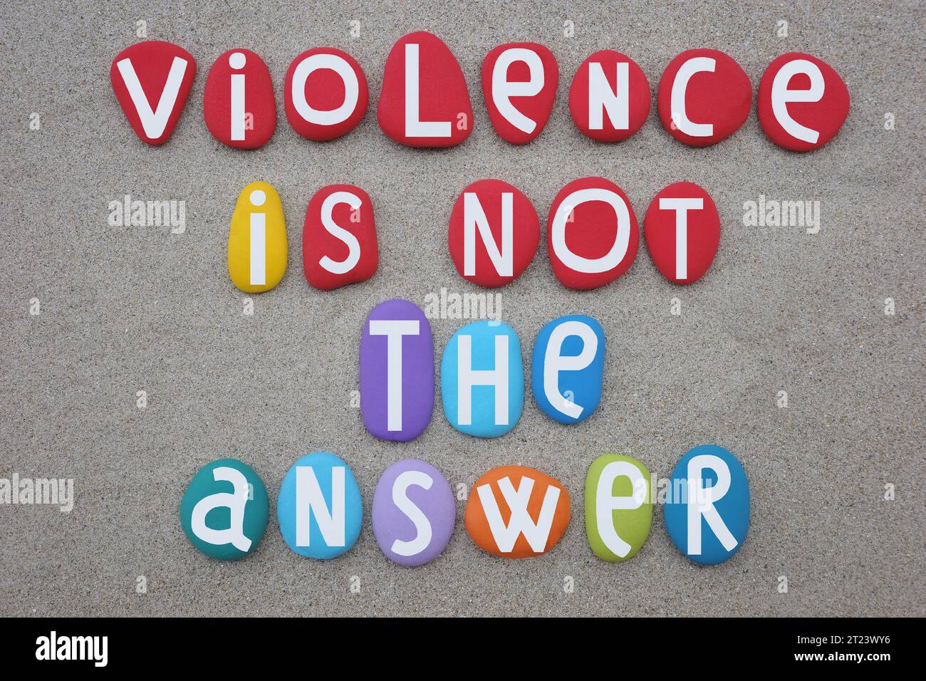 La violence n'est pas la réponse, slogan social créatif composé de lettres de pierre multicolores sur le sable de la plage Banque D'Images